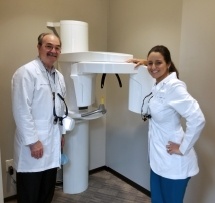 Houston dentists standing next to dental x ray machine