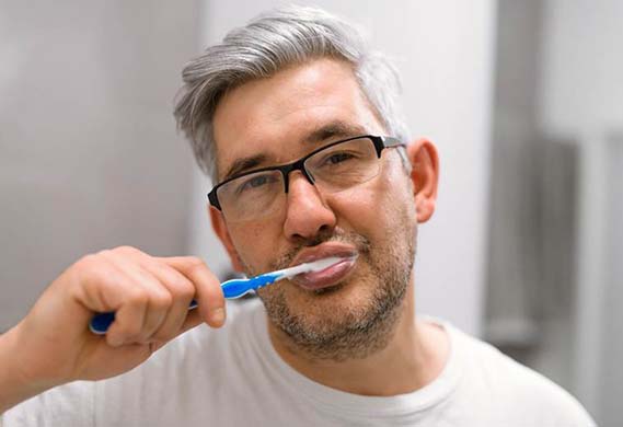Man brushing his teeth to prevent dental emergencies in Houston