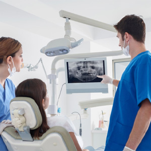 dentist showing a patient an X-ray of their mouth 