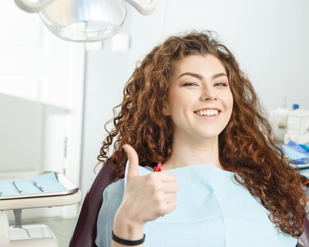 woman giving thumbs up before getting tooth extractions in Houston, TX 