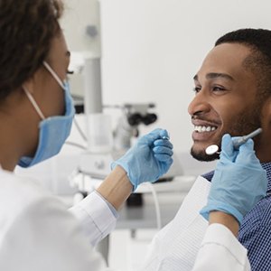 man at a checkup with his implant dentist in Houston 