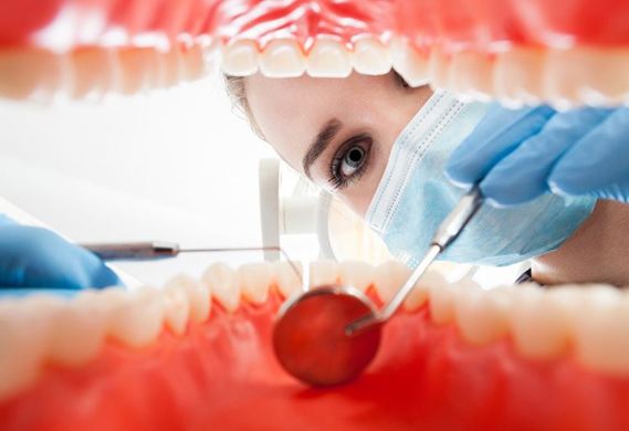 A dentist examining a patient’s gum tissue.