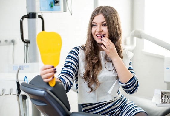 Woman in dental chair after laser dentistry treatment.