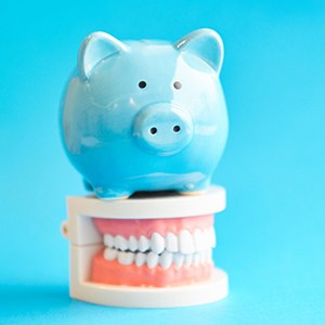 Piggy bank and teeth representing the cost of veneers in Houston 