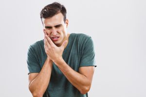 person suffering from tooth pain